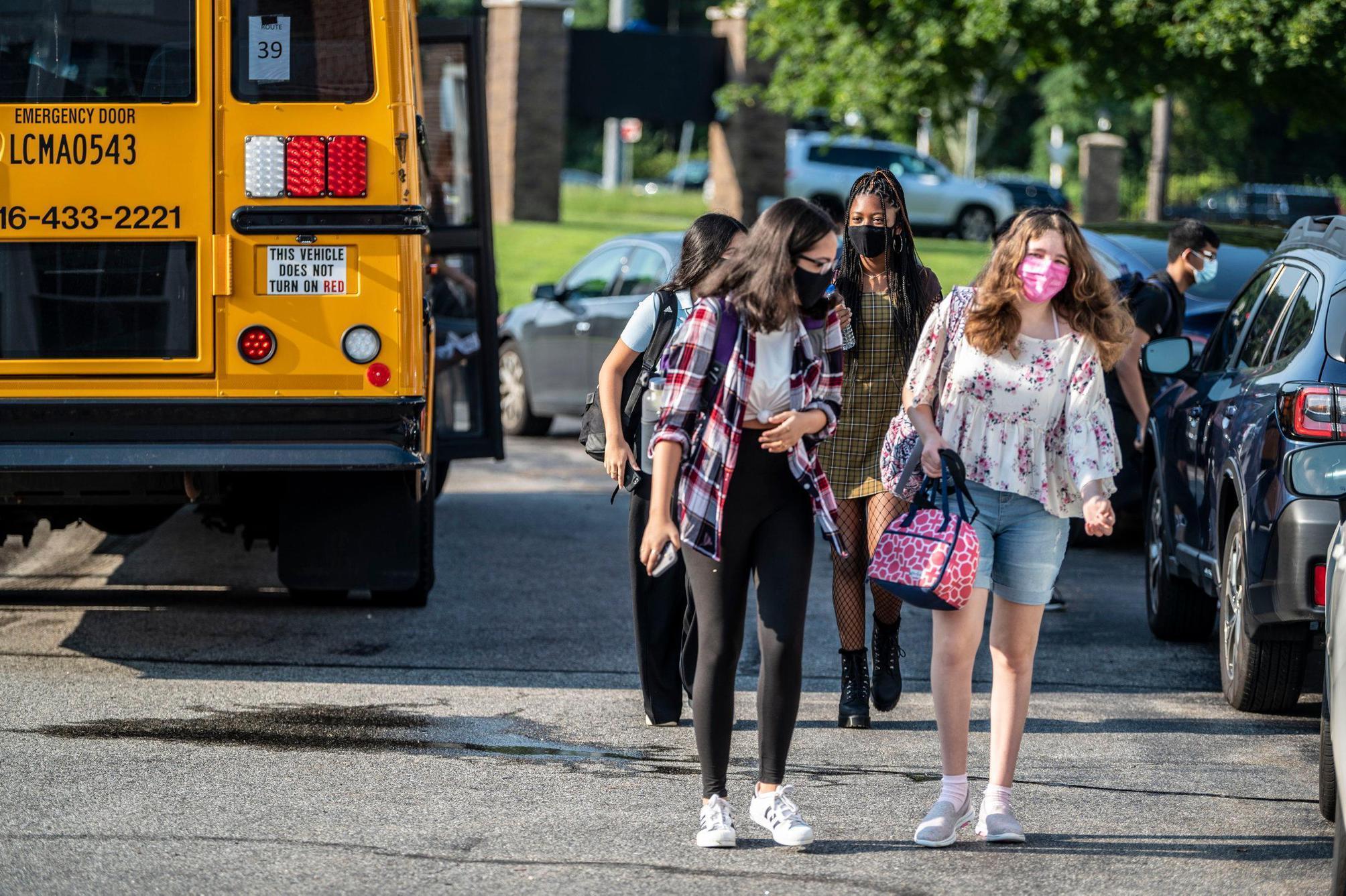 Students standing in front of a bus